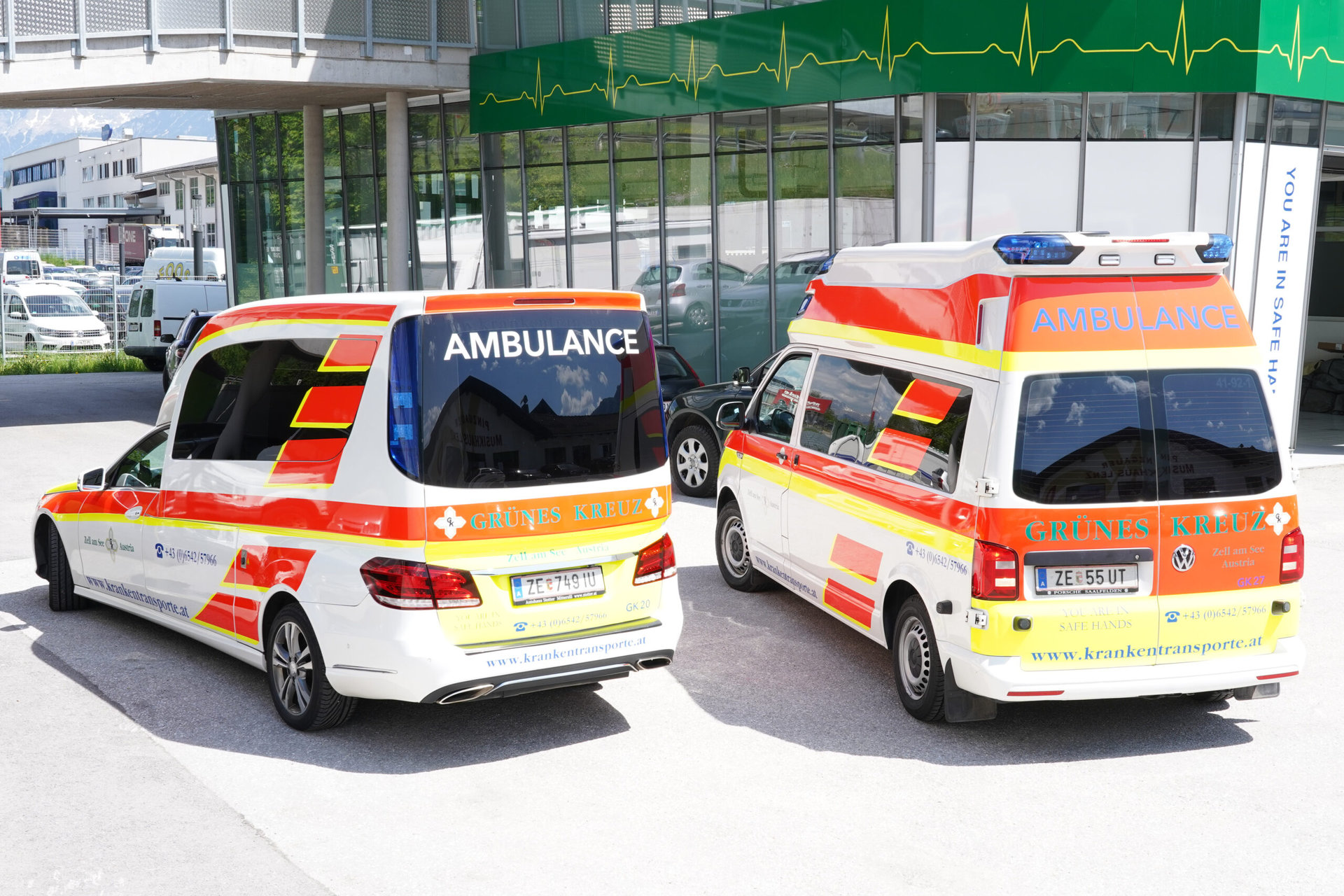 Two Grünes Kreuz ambulances in Zell am See in a car park.