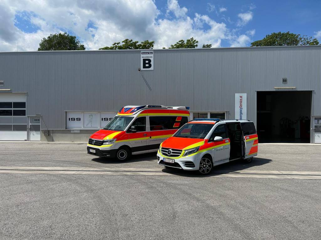 Zwei Krankenwagen vor einer modernen Lagerhalle in Zell am See, Österreich.